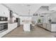 Open-concept kitchen with white cabinets, island with seating, and seamless flow to the living area at 18610 Ayrshire, Port Charlotte, FL 33981