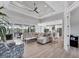 Open living area with tray ceiling, floor-to-ceiling windows, and neutral decor flowing into kitchen at 18610 Ayrshire, Port Charlotte, FL 33981