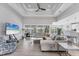 Spacious living room featuring a large sectional sofa, tray ceiling, and seamless flow to the lanai and kitchen at 18610 Ayrshire, Port Charlotte, FL 33981