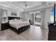 Main bedroom featuring a king bed, tray ceiling, and sliding glass doors leading to the pool area at 18610 Ayrshire, Port Charlotte, FL 33981