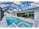 Beautiful screened-in pool with a spa, lounge chairs, and an outdoor seating area at 18610 Ayrshire, Port Charlotte, FL 33981