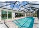Enclosed pool featuring a spa with lounge chairs, and outdoor cooking area at 18610 Ayrshire, Port Charlotte, FL 33981