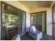 Cozy balcony with seating, sliding doors to the interior, and view of the outdoor foliage at 19505 Quesada Ave # B202, Port Charlotte, FL 33948