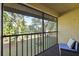 Screened balcony with furniture and view of lush greenery at 19505 Quesada Ave # B202, Port Charlotte, FL 33948