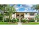 Inviting two-story condo with charming exterior, lush landscaping, and convenient stair access to the upper units at 19505 Quesada Ave # B202, Port Charlotte, FL 33948