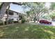 A well maintained condo building with mature trees, manicured lawn and adjacent parking at 19505 Quesada Ave # B202, Port Charlotte, FL 33948