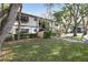 Scenic view of the condo building surrounded by beautiful, mature trees and lush green lawn at 19505 Quesada Ave # B202, Port Charlotte, FL 33948