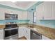 Modern kitchen with granite counters and stainless steel appliances at 19505 Quesada Ave # B202, Port Charlotte, FL 33948