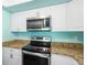 Gourmet kitchen featuring granite countertops and stainless steel appliances at 19505 Quesada Ave # B202, Port Charlotte, FL 33948