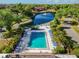Aerial view of a community pool with lounge chairs and a picturesque lake with a fountain at 19505 Quesada Ave # B202, Port Charlotte, FL 33948