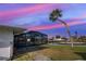 Waterfront backyard with palm tree and screened-in pool, offering serene outdoor living and water access at 202 South Dr, Englewood, FL 34223