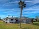 A backyard view features a screened-in pool area, a well-maintained lawn, and mature trees, offering privacy at 202 South Dr, Englewood, FL 34223