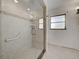 Bathroom features a glass-enclosed shower with tile surround and a grab bar at 202 South Dr, Englewood, FL 34223