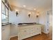 Bathroom with double vanity, wood floors, and decorative lighting with plenty of natural light at 202 South Dr, Englewood, FL 34223