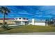 Bright two-story home featuring a two-car garage with attached covered parking and a well-manicured front lawn at 202 South Dr, Englewood, FL 34223