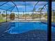 Inviting pool with screened enclosure surrounded by a paved patio with a view of the water at 202 South Dr, Englewood, FL 34223