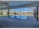 Inviting in-ground pool within a screened enclosure, surrounded by brick pavers and tropical landscaping at 202 South Dr, Englewood, FL 34223