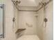 Newly remodeled tiled shower with dual shower heads, bench, and grab bar for added safety at 202 South Dr, Englewood, FL 34223