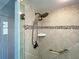 Updated shower with tile surround, mosaic accent tile, handheld shower head, and safety bar at 202 South Dr, Englewood, FL 34223