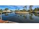 Picturesque waterfront view featuring a private dock, calm waters, and verdant tropical landscaping at 202 South Dr, Englewood, FL 34223