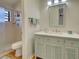 Bathroom with light green vanity, tiled shower and mirror at 220 Southampton Drive # 325, Venice, FL 34293