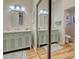 Well-lit bathroom with dual vanities, a large mirror, and a shower at 220 Southampton Drive # 325, Venice, FL 34293