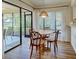 Dining area with a round wood table set for four and modern hanging light fixture at 220 Southampton Drive # 325, Venice, FL 34293