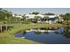 Exterior view of a beautiful community building with a lake, golf course, and lush landscaping at 220 Southampton Drive # 325, Venice, FL 34293