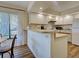 View of the kitchen with white cabinets and appliances and a bar at 220 Southampton Drive # 325, Venice, FL 34293