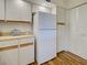 Bright kitchen featuring white cabinets, appliances, and wood-look floors at 220 Southampton Drive # 325, Venice, FL 34293