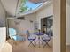Outdoor patio with blue table set, lounge chair, butterfly accents and sliding glass door at 220 Southampton Drive # 325, Venice, FL 34293