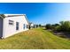 Manicured backyard with a long, green lawn and tidy landscaping at 24135 Buckingham Way, Punta Gorda, FL 33980