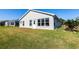 Well-kept backyard featuring lush green lawn, a patio, and natural light at 24135 Buckingham Way, Punta Gorda, FL 33980