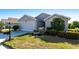 Beautifully landscaped home features a two-car garage, manicured lawn, and colorful shrubs at 24135 Buckingham Way, Punta Gorda, FL 33980
