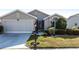 Charming home featuring a two-car garage, meticulous landscaping, and a welcoming entrance at 24135 Buckingham Way, Punta Gorda, FL 33980