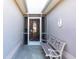 Welcoming front porch features a charming bench and decorative door, creating a warm entry at 24135 Buckingham Way, Punta Gorda, FL 33980