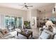 Bright living room with ceiling fan, glass enclosed porch, and view to dining area at 24135 Buckingham Way, Punta Gorda, FL 33980