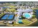 Overhead shot of community amenities: tennis, bocce, shuffleboard, pool and clubhouse overlooking a lake at 24135 Buckingham Way, Punta Gorda, FL 33980