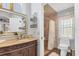 Bathroom vanity with granite countertop and adjacent shower with decorative tile at 2418 Herron Ter, Port Charlotte, FL 33981