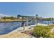 Close-up view of a private boat dock with a boat lift on a sunny day with clear water at 2418 Herron Ter, Port Charlotte, FL 33981