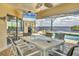 Covered lanai with a dining table, outdoor seating, and a scenic view of the pool and waterfront, great for gatherings at 2418 Herron Ter, Port Charlotte, FL 33981