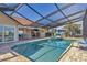 Resort-style screened-in pool and spa area with comfortable seating, ideal for leisure and enjoying the tropical surroundings at 2418 Herron Ter, Port Charlotte, FL 33981