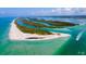 Stunning aerial view of a pristine coastline with crystal-clear turquoise water and lush island vegetation at 2572 Sherman Oak Dr, North Port, FL 34289