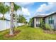 Backyard showcasing green lawn, side fence, landscaping, and views of the screened-in patio at 2572 Sherman Oak Dr, North Port, FL 34289