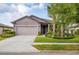 Charming single-story home featuring a well-manicured lawn, an attached two-car garage and lovely landscaping at 2572 Sherman Oak Dr, North Port, FL 34289