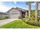 Attractive single-story house with an attached two-car garage and a meticulously maintained front yard with mature landscaping at 2572 Sherman Oak Dr, North Port, FL 34289