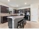 Modern kitchen with dark cabinets, granite counters, and stainless steel appliances at 2572 Sherman Oak Dr, North Port, FL 34289