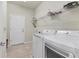Functional laundry room featuring white washer and dryer, wire rack shelving, and door to exterior at 2572 Sherman Oak Dr, North Port, FL 34289