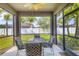 Relaxing screened patio with a ceiling fan and outdoor furniture overlooking the lush green lawn at 2572 Sherman Oak Dr, North Port, FL 34289