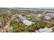 Stunning aerial view of a home nestled amongst lush greenery with waterfront views in the distance at 2760 Lemon Ave, Englewood, FL 34223